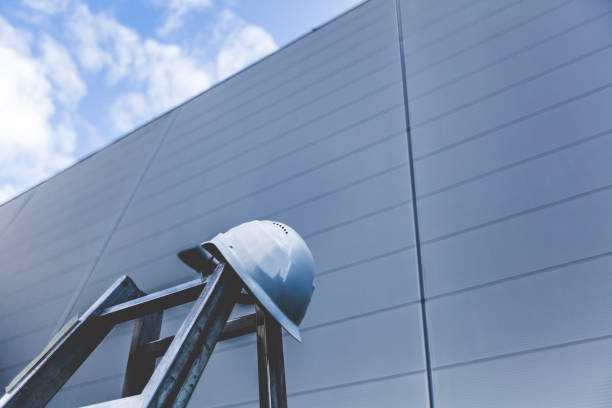 working man?s helmet on ladder in front of a huge wall. high goals for success. working man´s helmet on ladder in front of a huge wall. high goals for success.