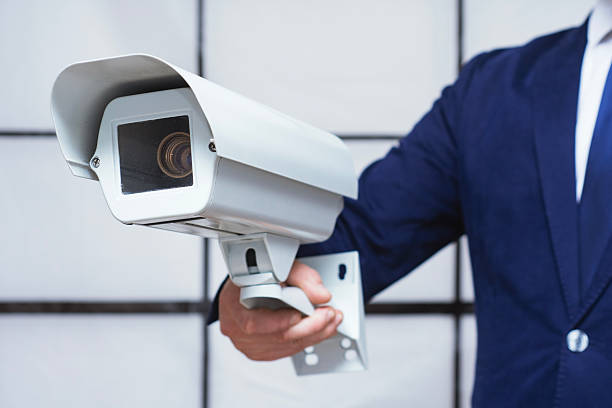 Businessman holding security camera. Surveillance system installation and property protection. Concept of safety, monitoring, control, privacy and modern security technology for business and home