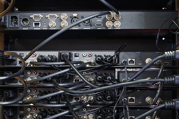 Tangled cables and connectors creating a complex network on the back of server racks, illustrating data infrastructure and technology